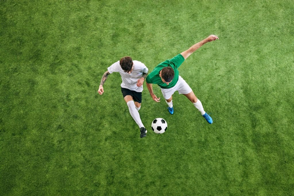 Two soccer players competing for ball on field.