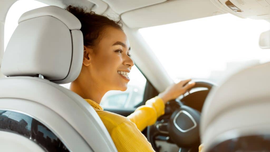 Smiling person driving a car