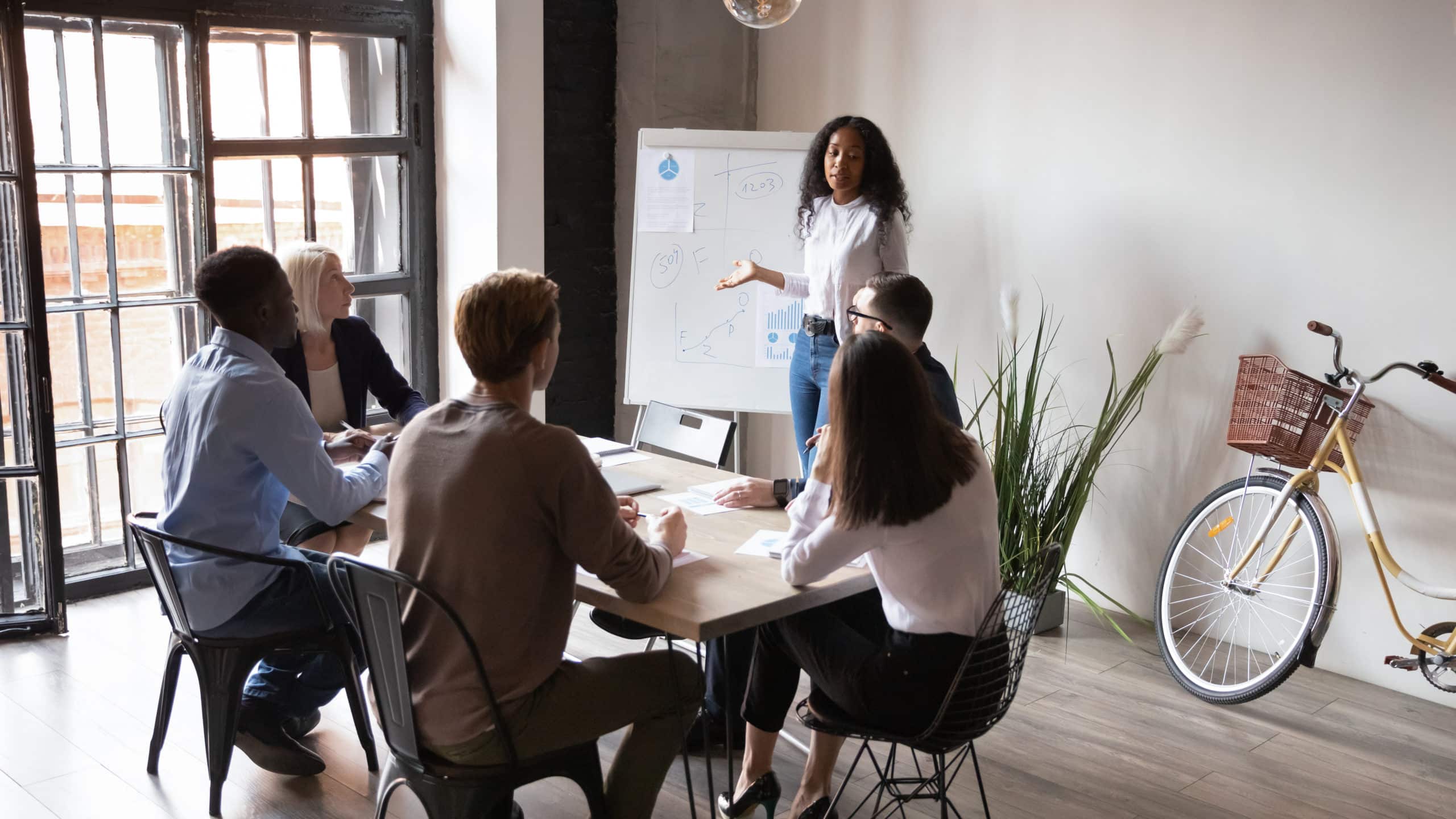 African businesswoman coach presenter give whiteboard business presentation in modern office boardroom