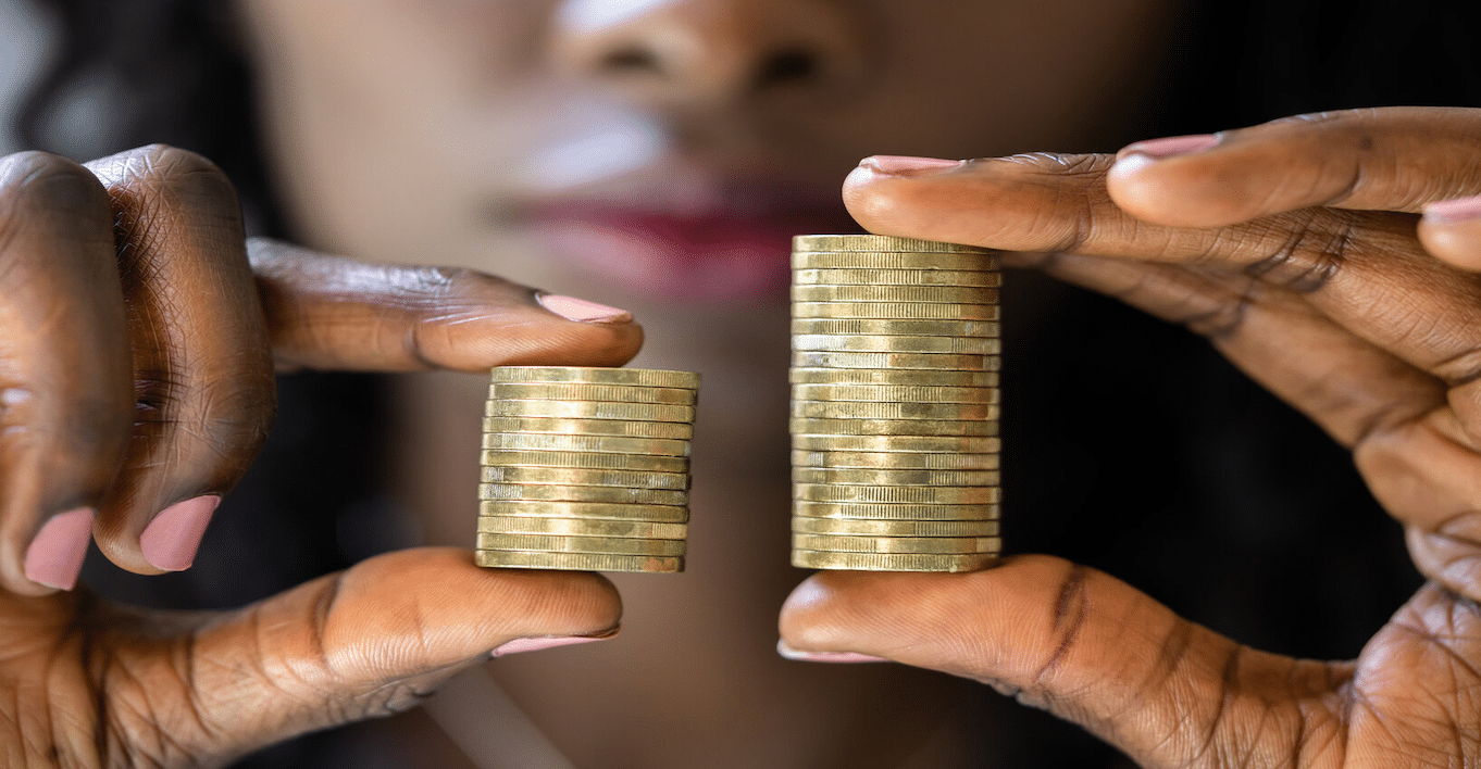 woman holding two different size stacks of coins