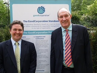 Leo Martin and a man standing by the GoodCorporation standard