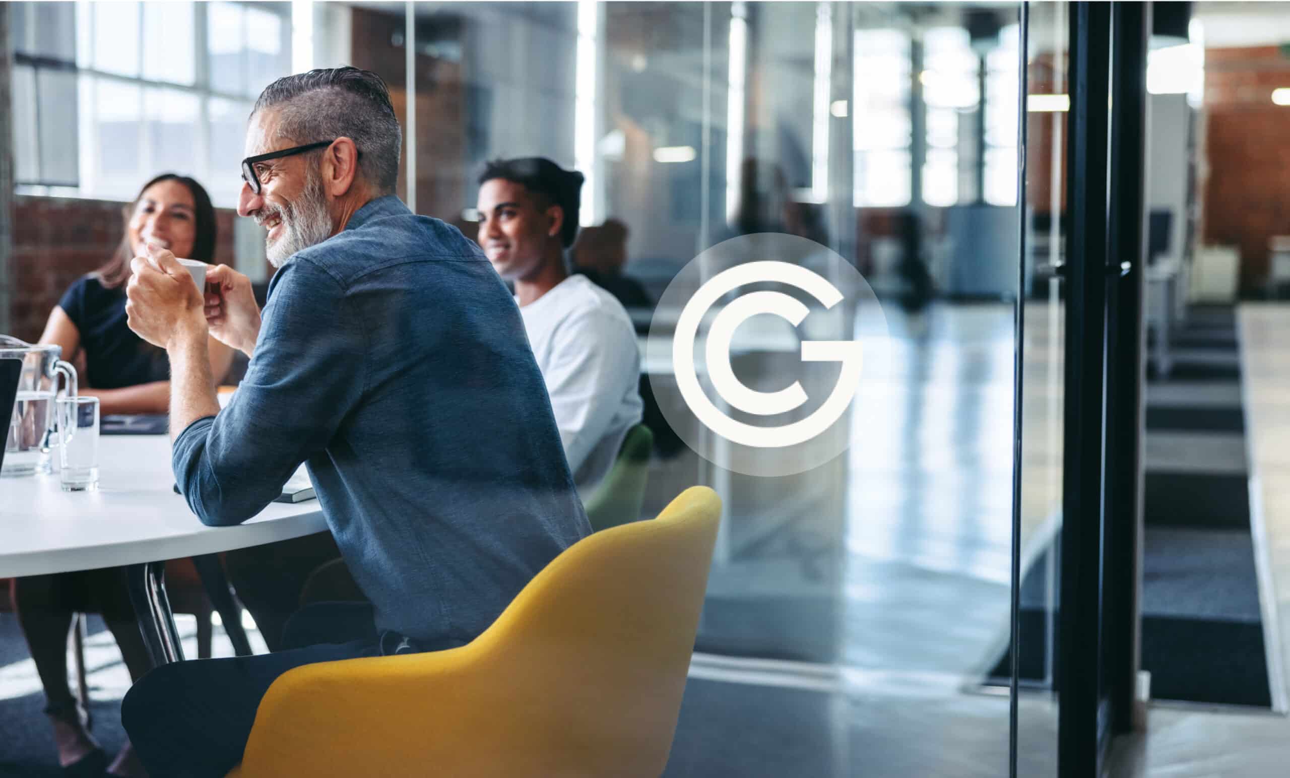 a team of colleagues smiling and chatting in an office