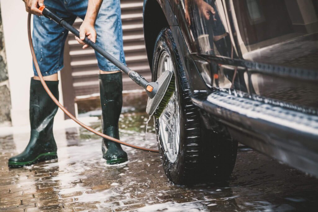 person power washing a car