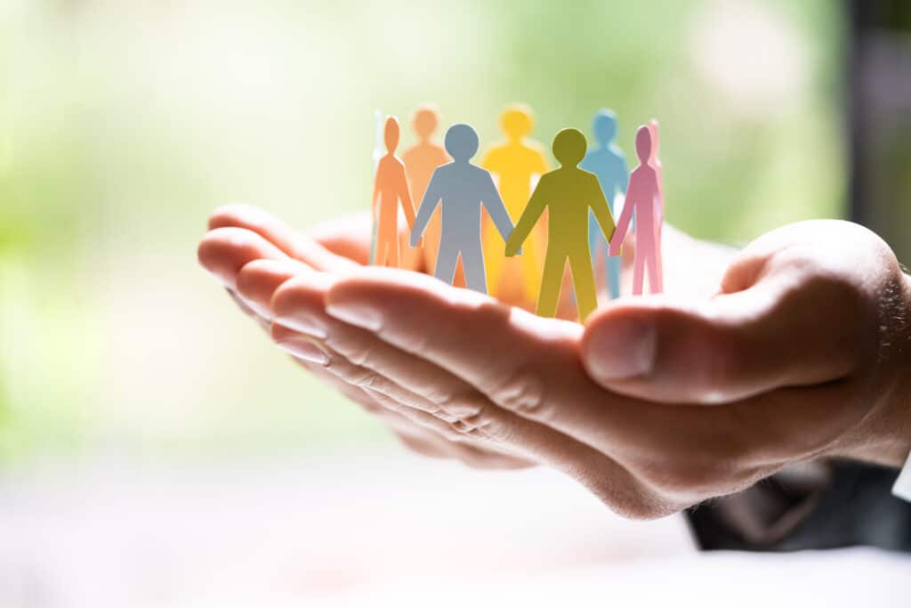 hands holding a paper chain of people in a circle