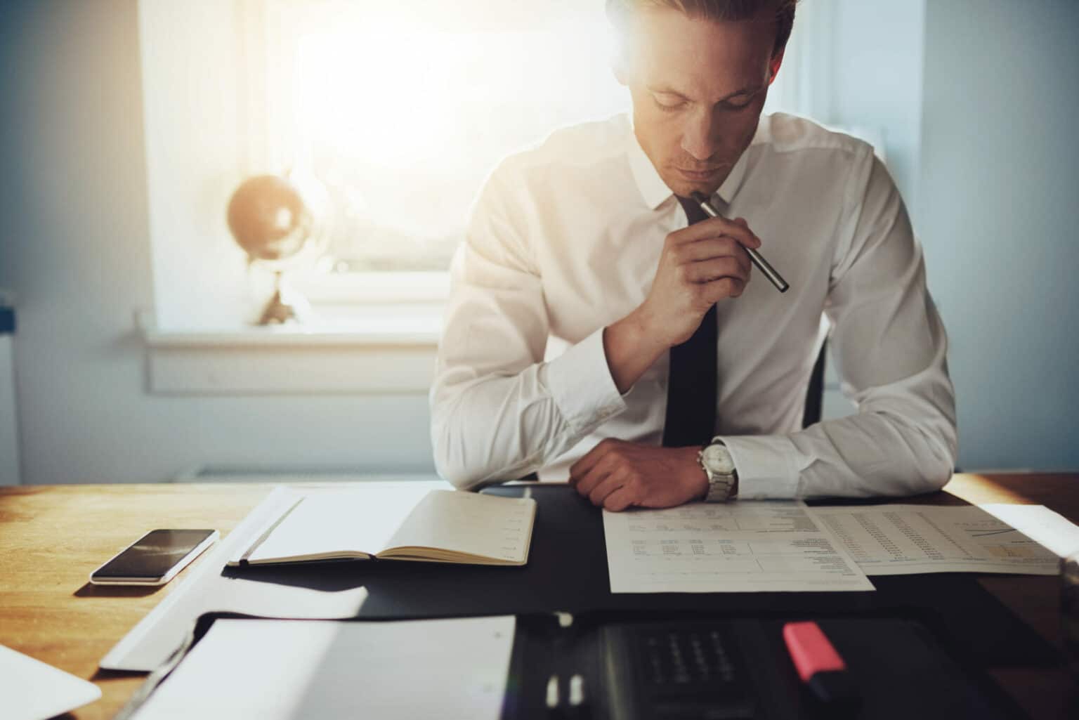 man working hard at a desk looking over documents