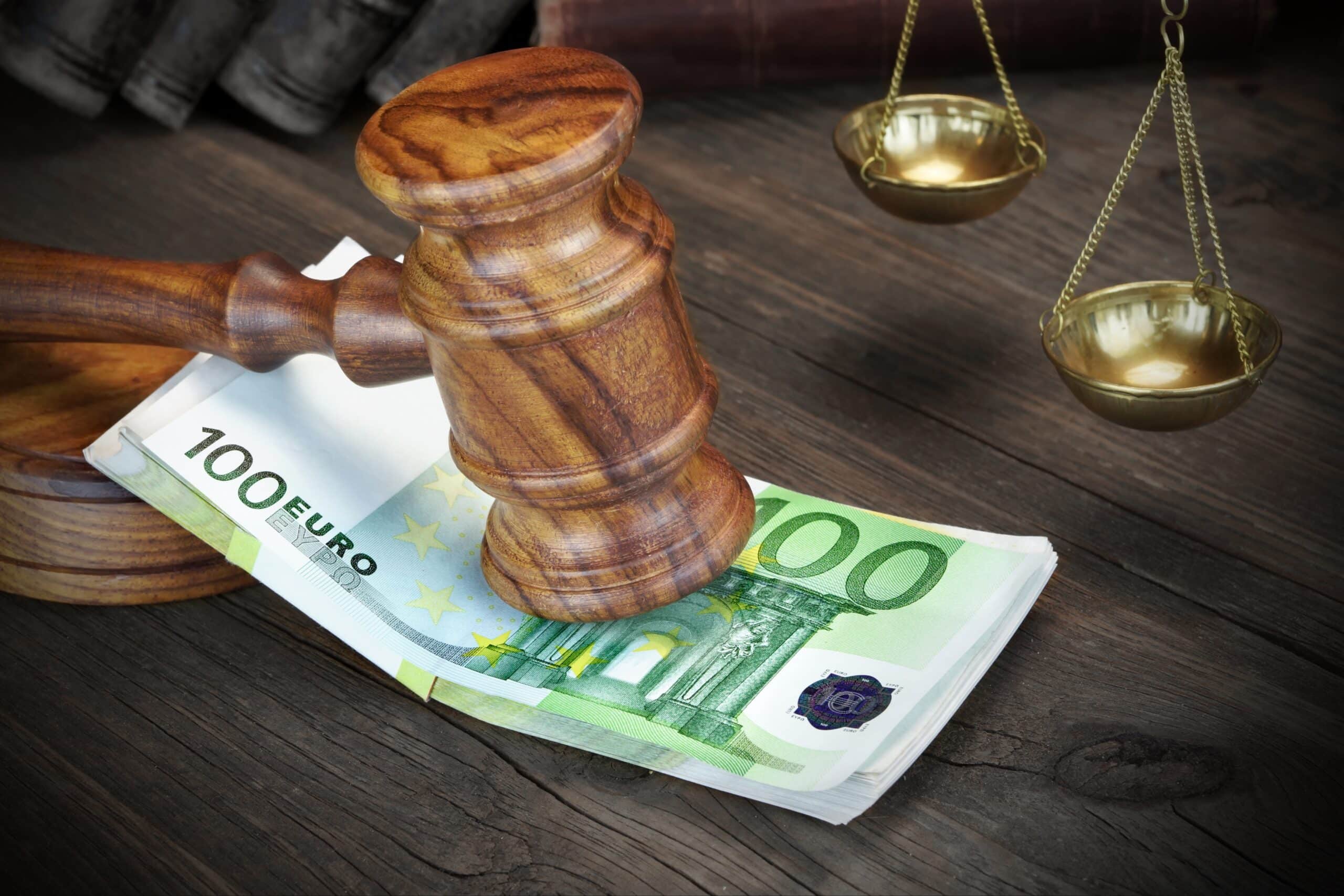 Gavel hammering onto a stack of 100 Euro notes