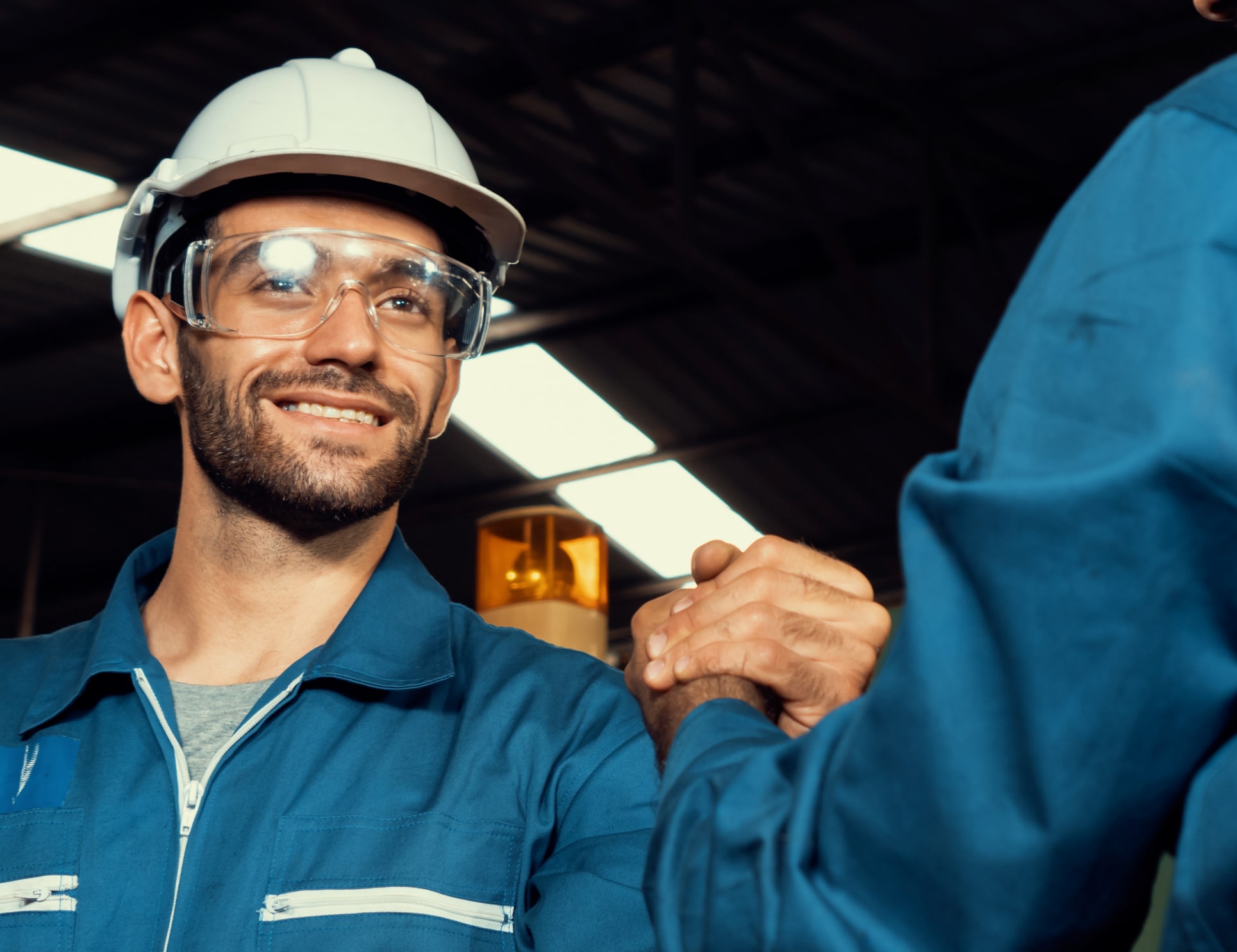 two men in construction gear shaking hands