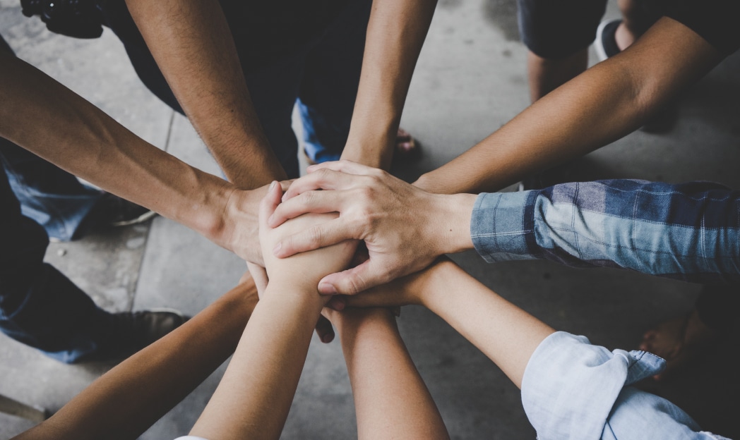 people joining hands in a circle