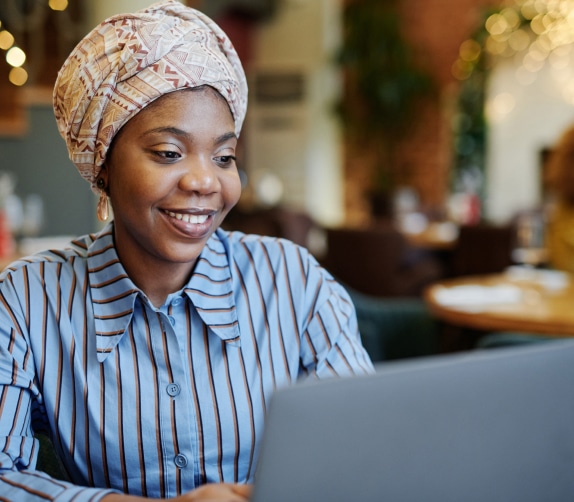 Smiling woman working in a cafe on her laptop