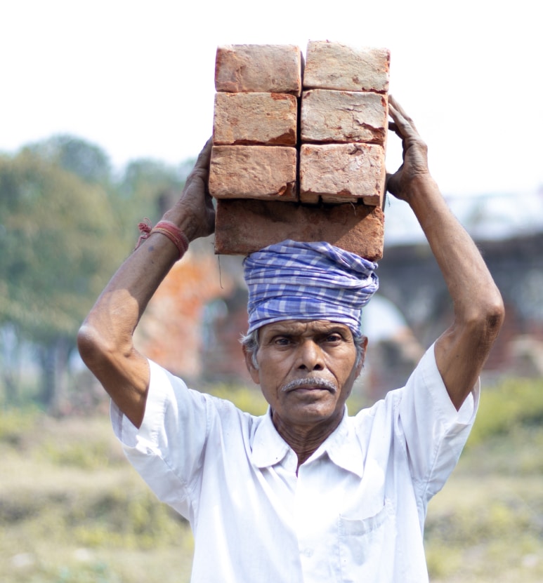 Male worker carrying bricks on his head