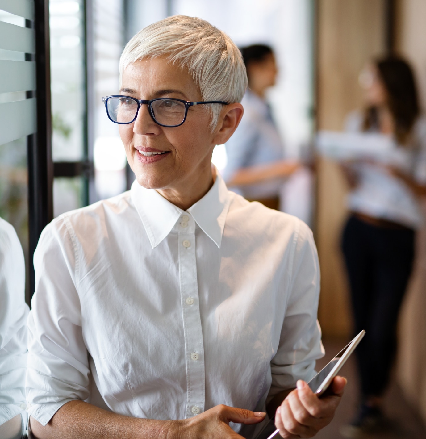 Woman wearing a white shirt and carrying a tablet device