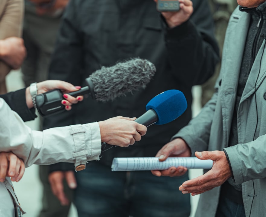 close up of journalists trying to interview a whistleblower