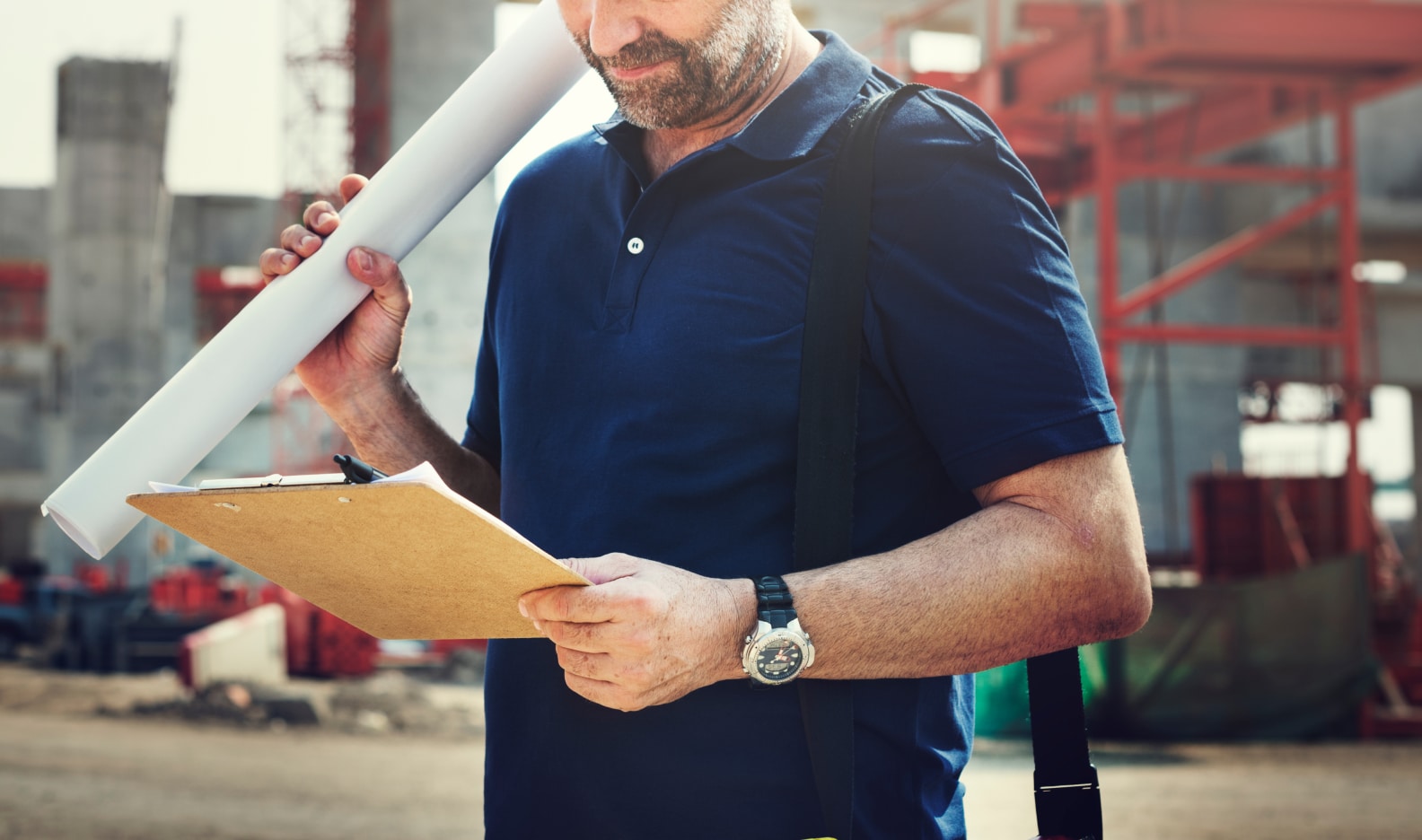 site engineer on a construction site reading a form from a clipboard