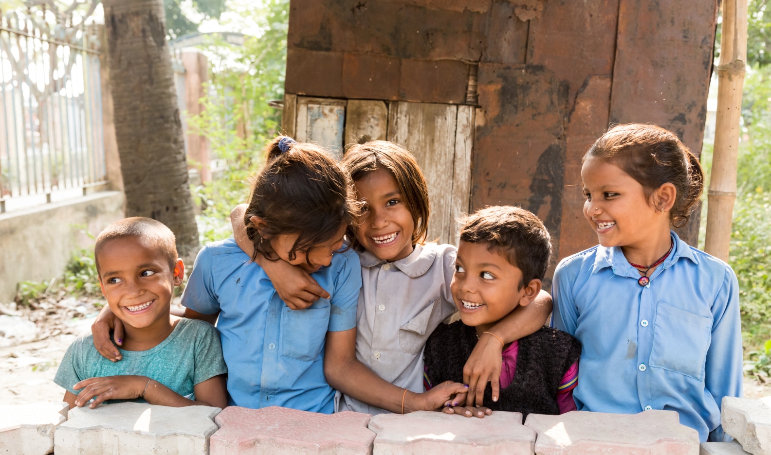 group of school children smiling and hugging each other