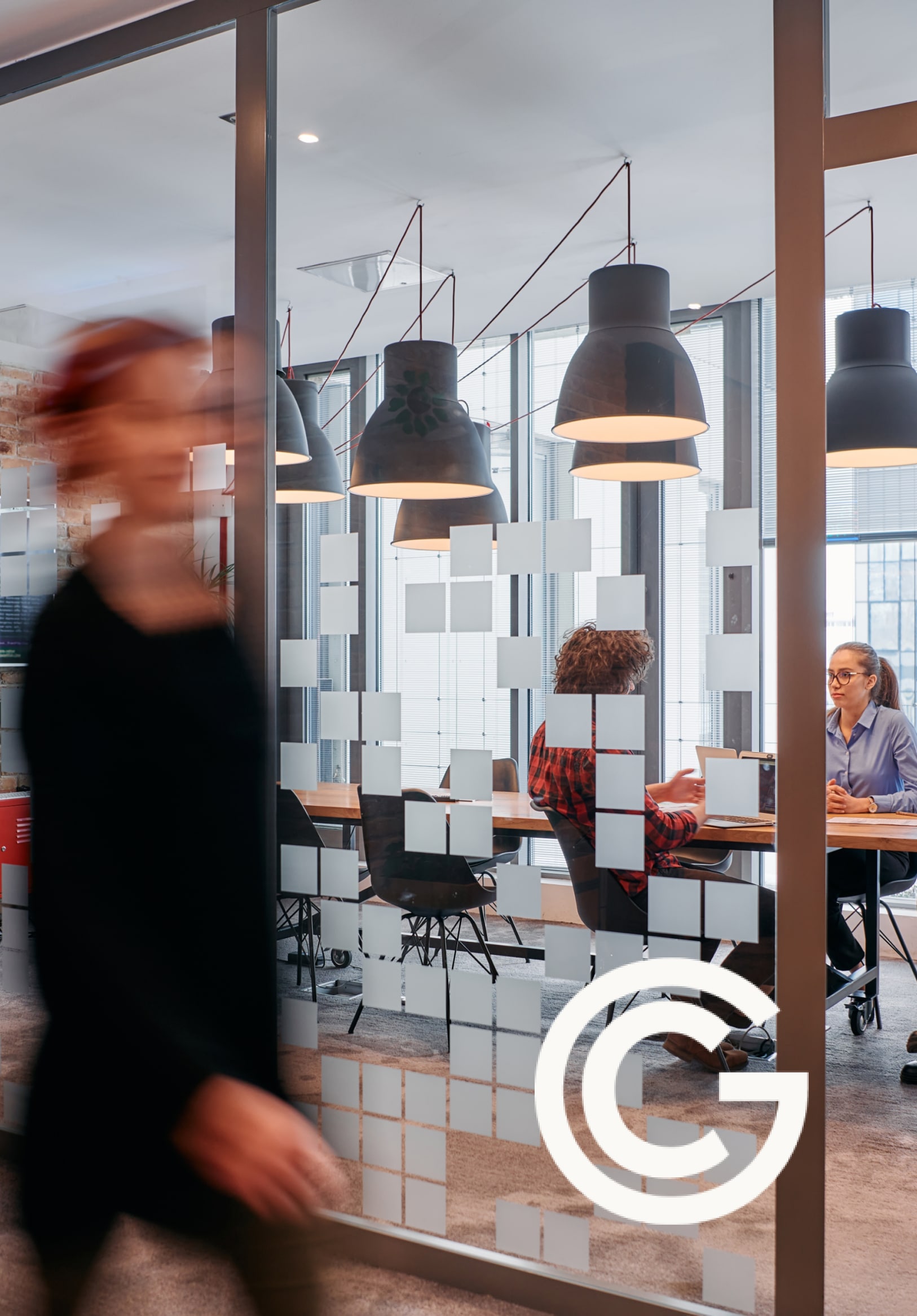 busy office with glass walls and people working