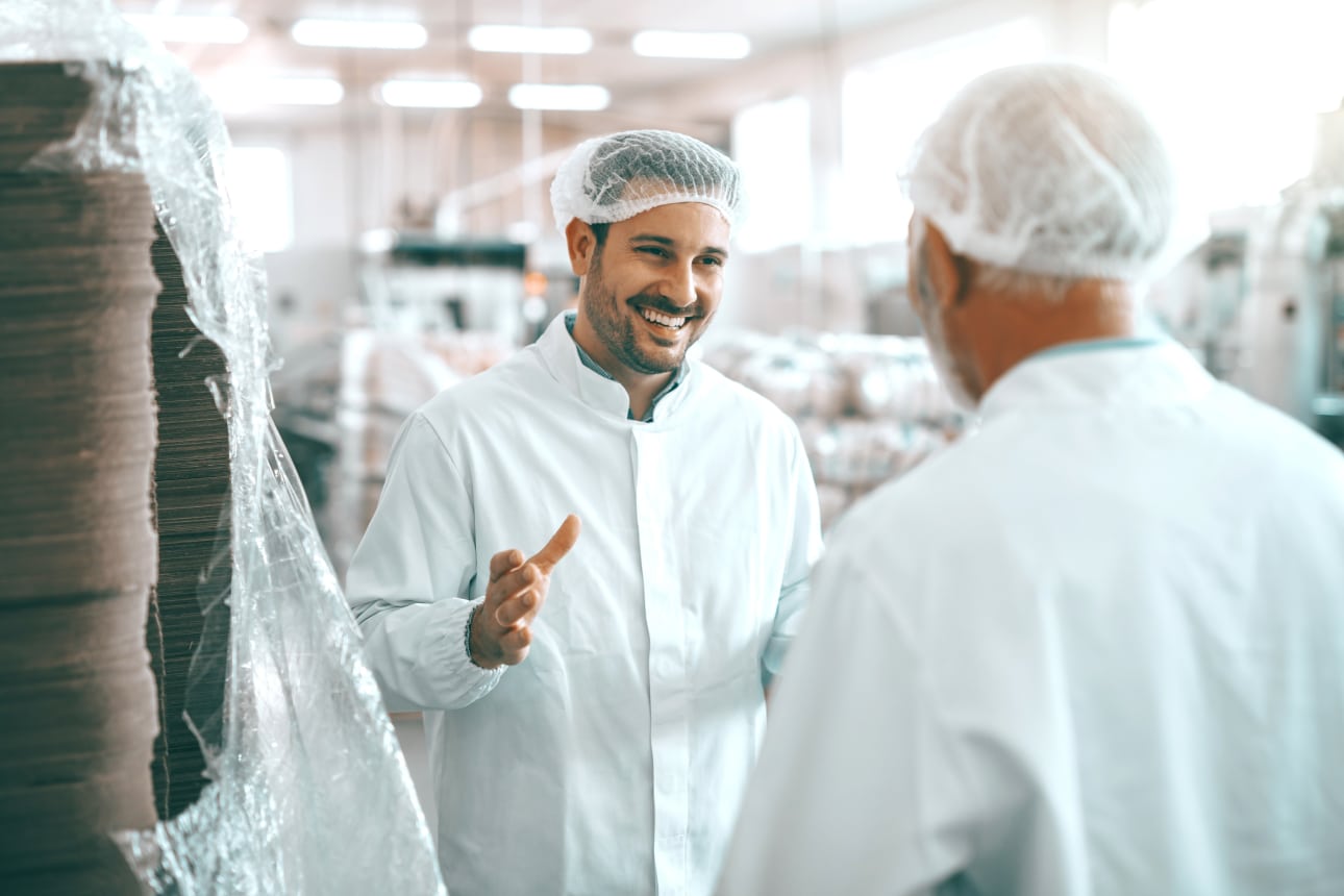 Man smiling at his colleague in a factory