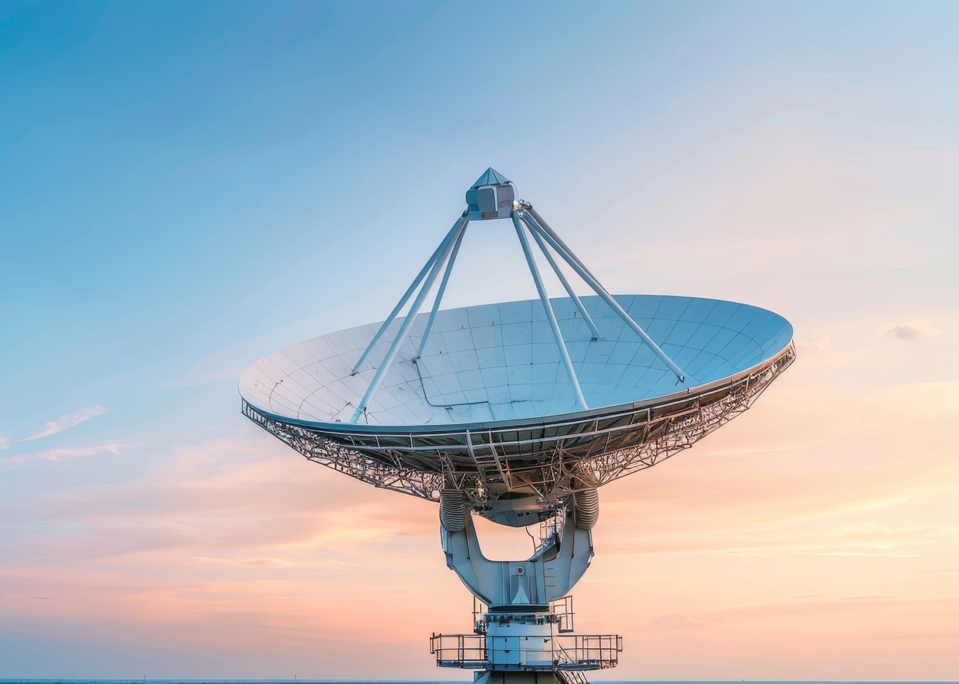 large satellite dish antenna against sunset sky