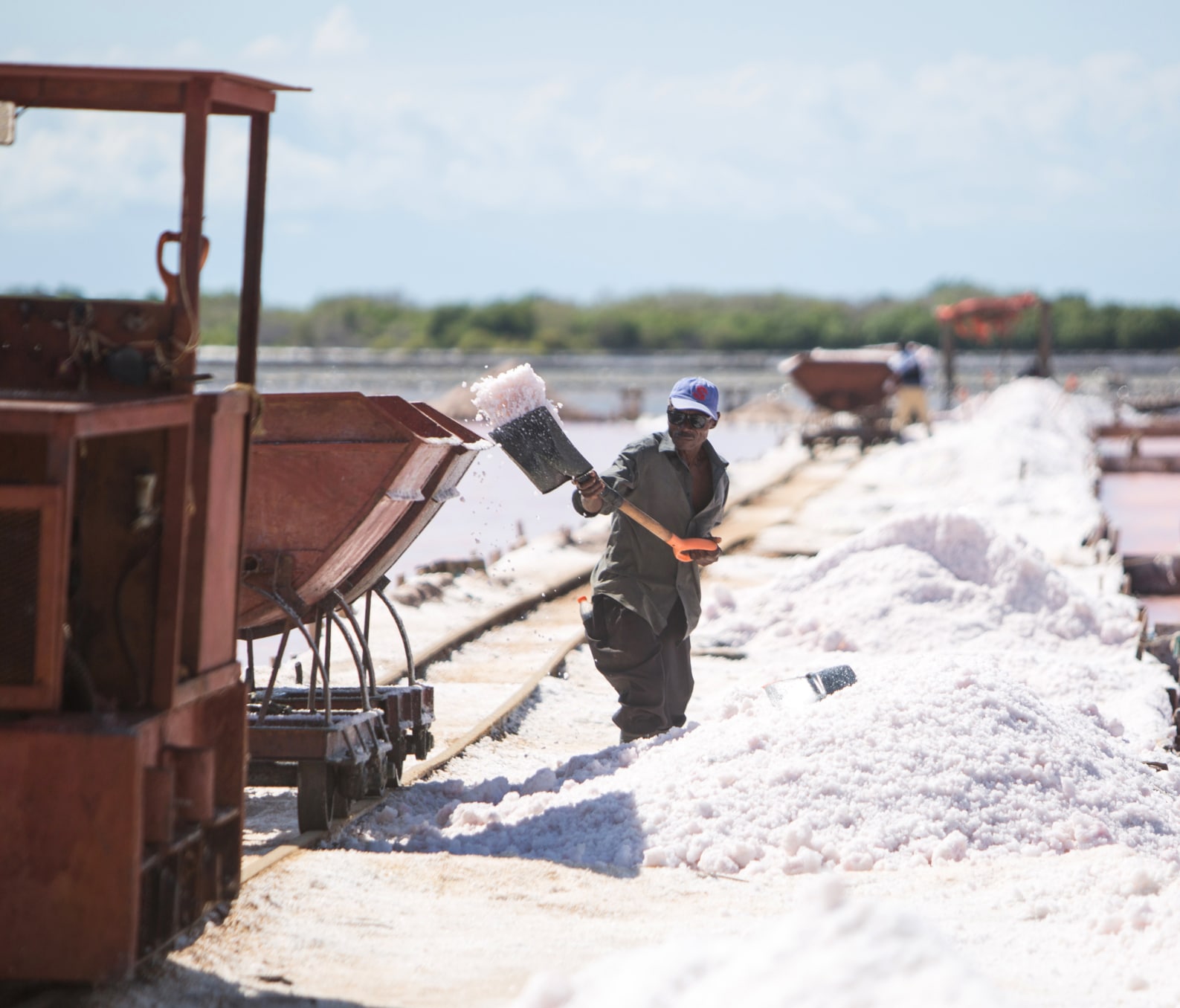 Worker shovelling product into a filtering truck