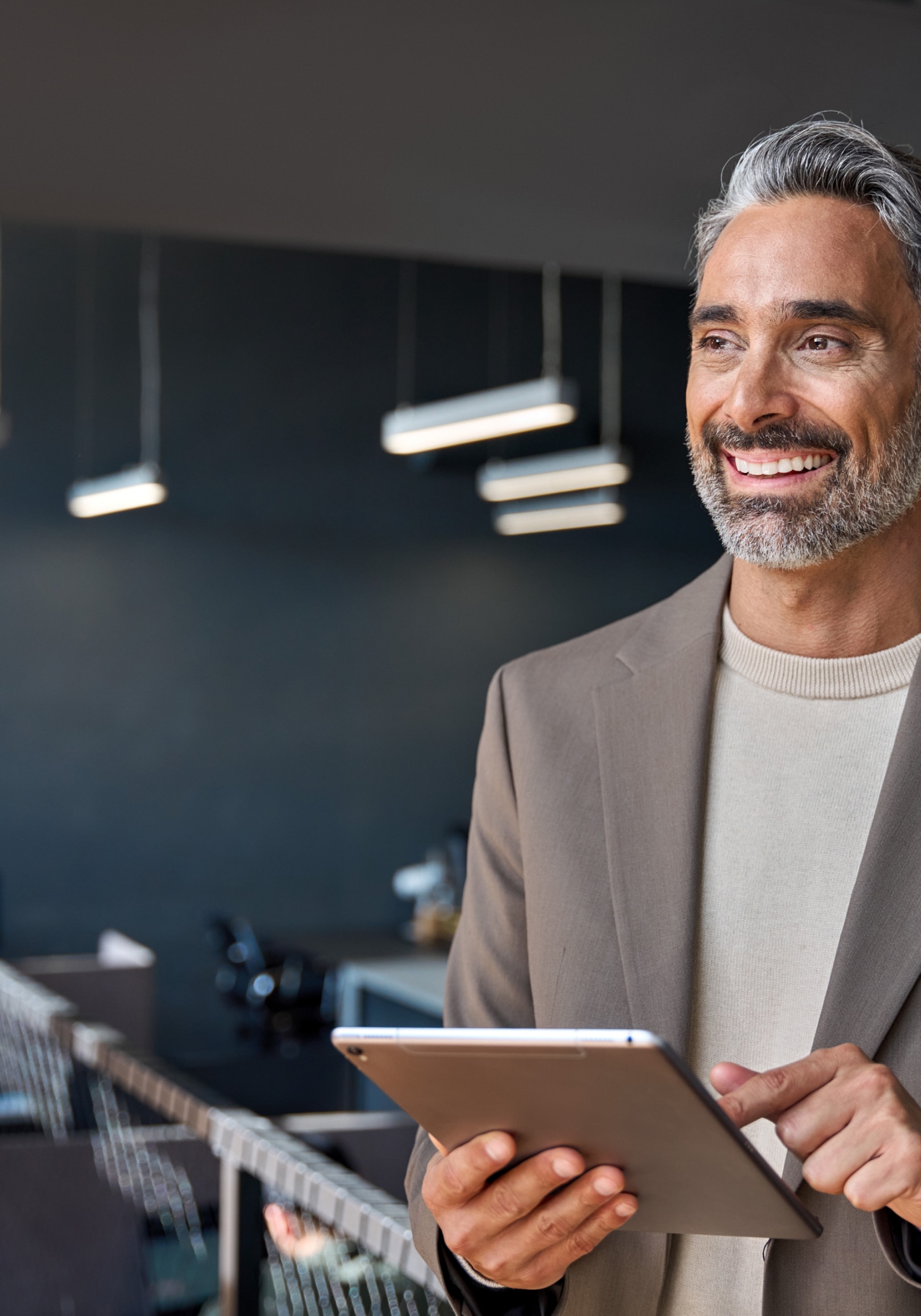 Smartly dressed man using a tablet device and smiling