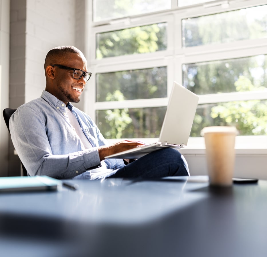 Man smiling and looking at his laptop screen