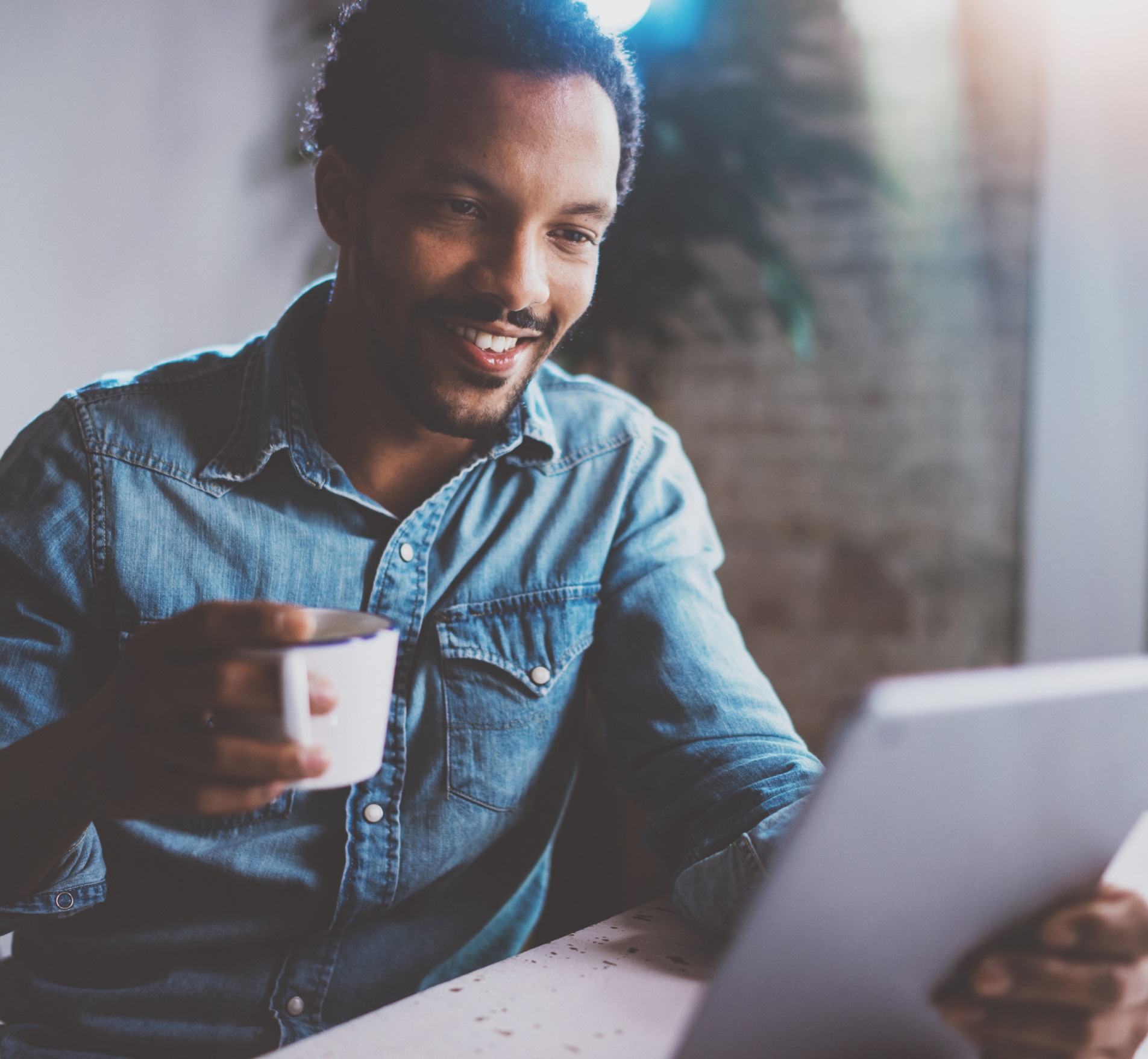 Man holding a tablet device smiling