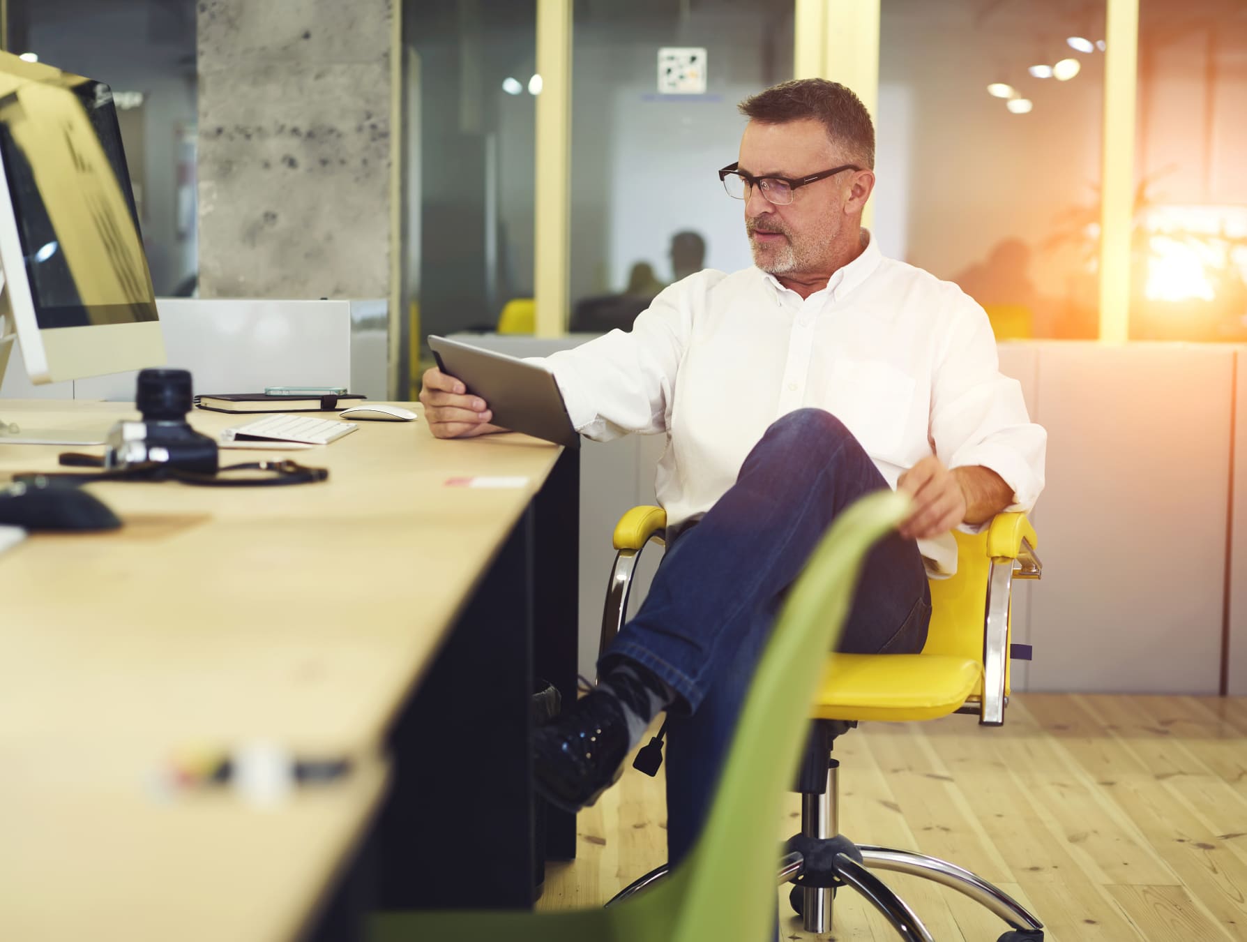 Man sitting at a desk chair using a tablet