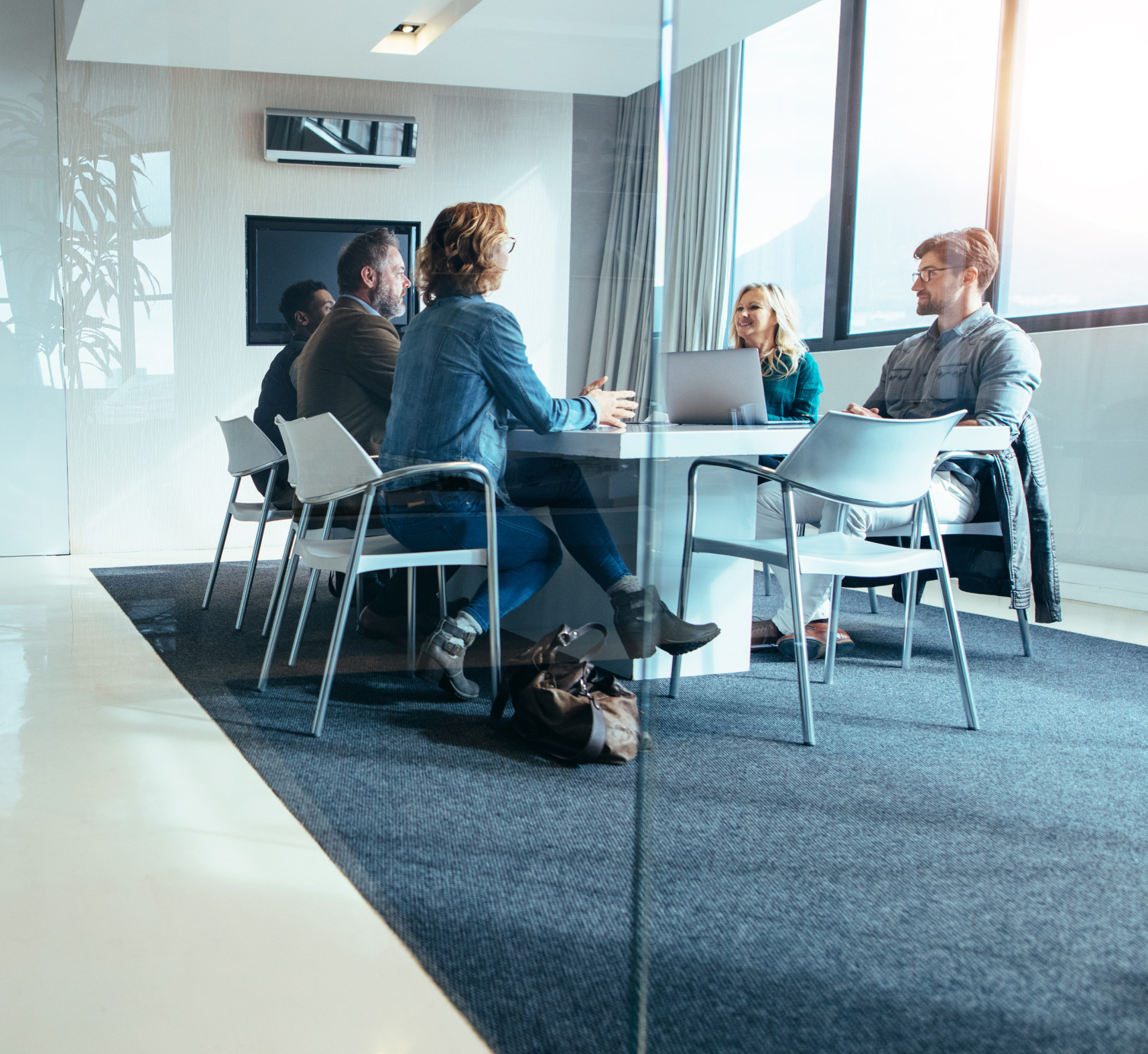 team of colleagues sat at an office table having a meeting